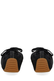 Givenchy women’s minimal slim sneaker in black canvas with tan rubber soles and black laces shown from the back