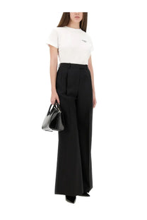Black leather handbag with structured design and top handles shown alongside Givenchy women’s white shirt