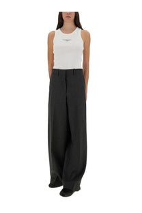 Black wide-leg trousers with tailored fit and subtle creases paired with Givenchy women’s slim white tank top