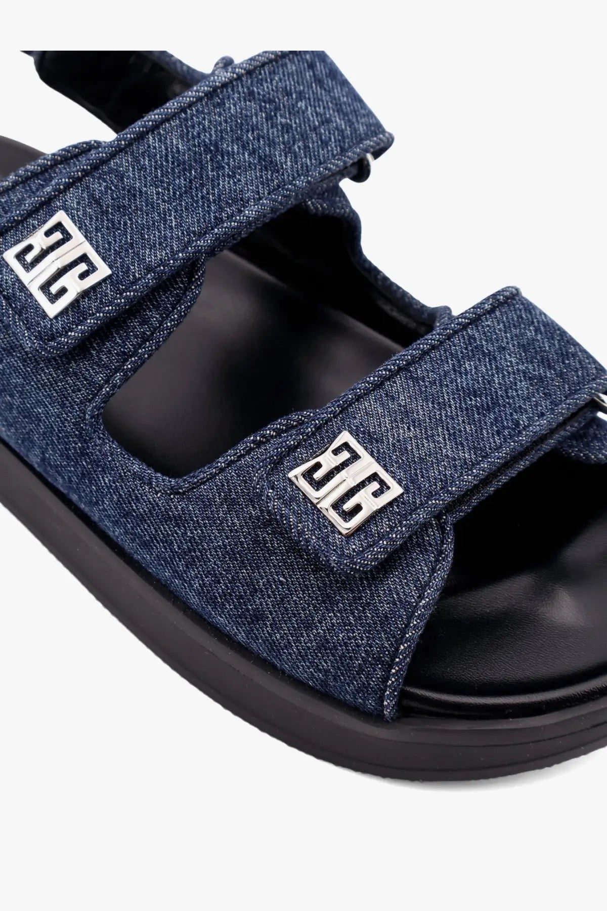 Givenchy women’s flat denim sandals in blue featuring silver metallic logo accents on the straps