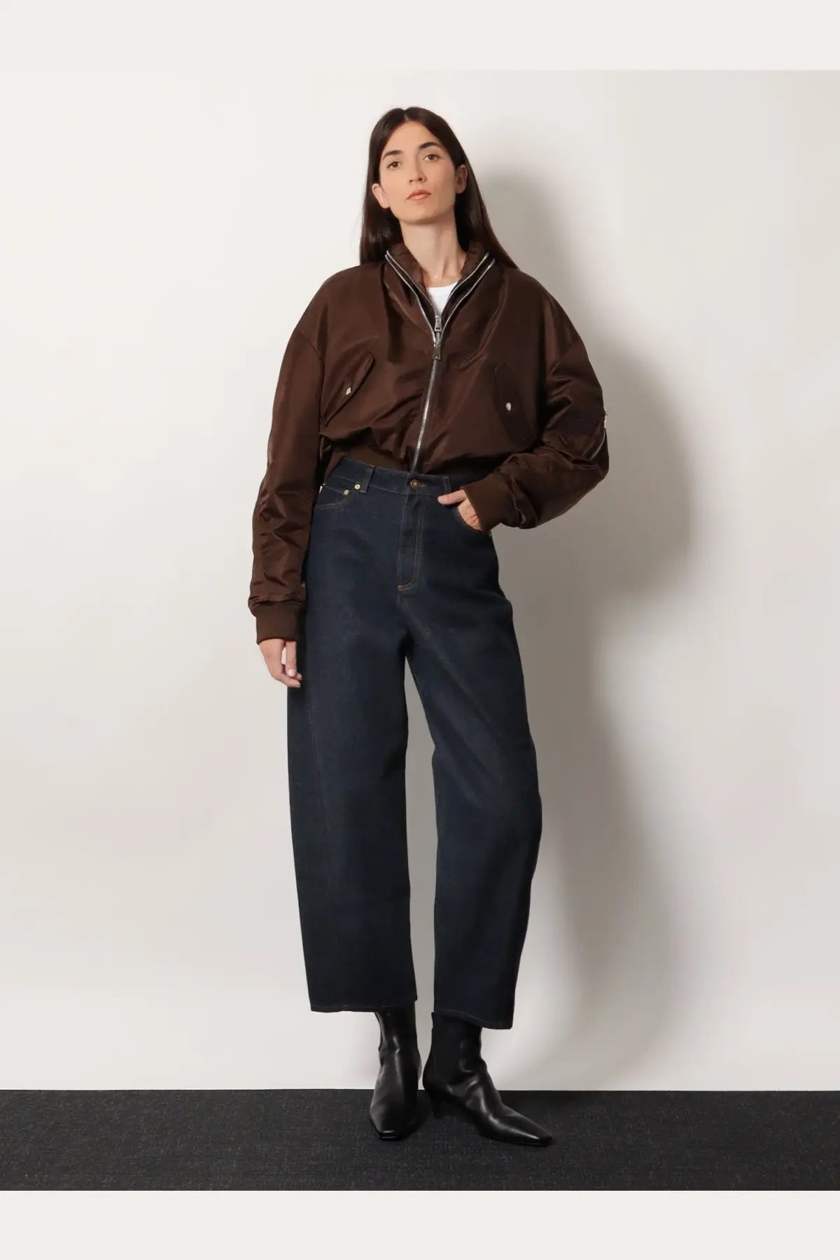 Brown bomber jacket with zipper front and two chest pockets paired with givenchy women’s twisted dark blue denim jeans
