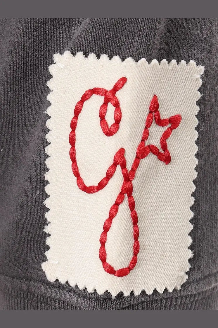 White patch with red embroidered logo on dark gray cotton fabric of Golden Goose men’s Archibald distressed sweatshirt