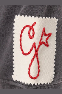 White patch with red embroidered logo on dark gray cotton fabric of Golden Goose men’s Archibald distressed sweatshirt