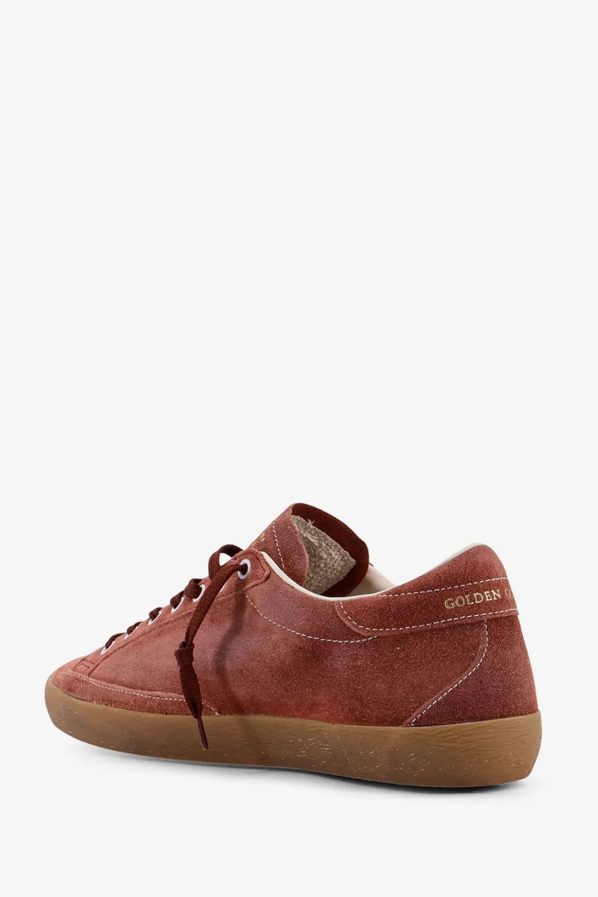 Back side of a rust-colored suede golden goose men’s super star double quarter sneaker with tan rubber sole and laces
