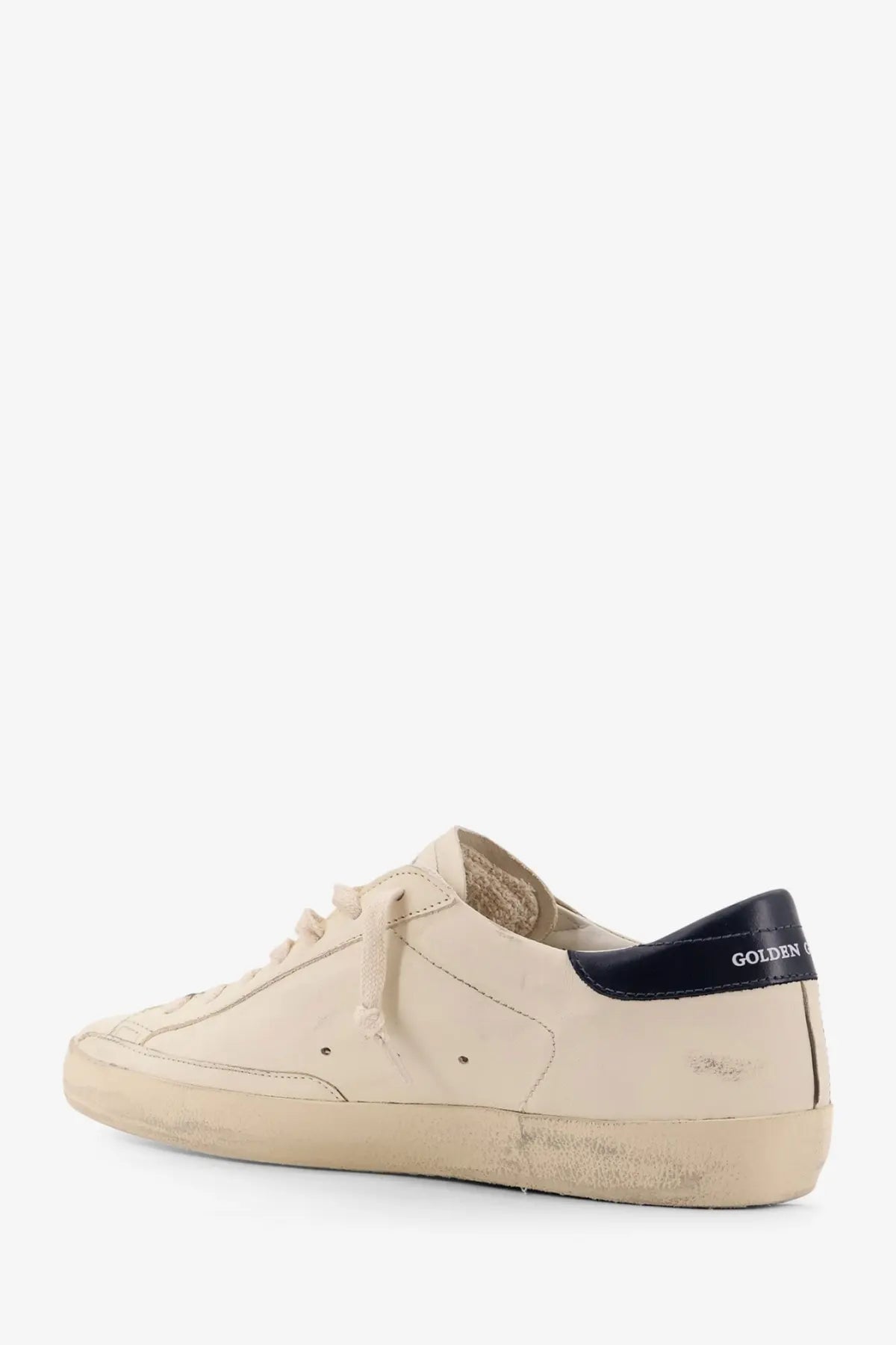 Beige leather golden goose men’s super star low-top sneaker with black rubber heel tab and distressed sole