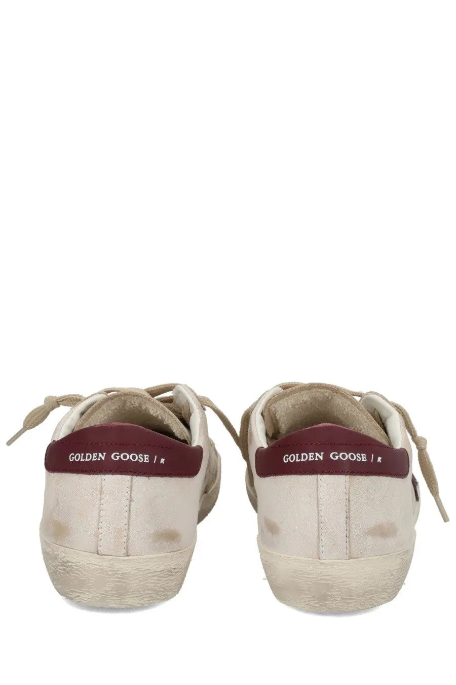 Cream-colored suede Golden Goose men’s Superstar sneakers with distressed look and maroon heel tabs with logo visible from back