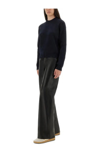 Black leather flare pants shown from the back paired with golden goose women’s cotton jersey blue top