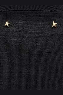 Gold star-shaped stud earrings displayed on a black virgin wool knit sweater from golden goose women’s dilara collection