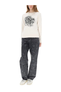 Cream-colored vce sweatshirt with black floral and circular logo design paired with golden goose women’s black jeans