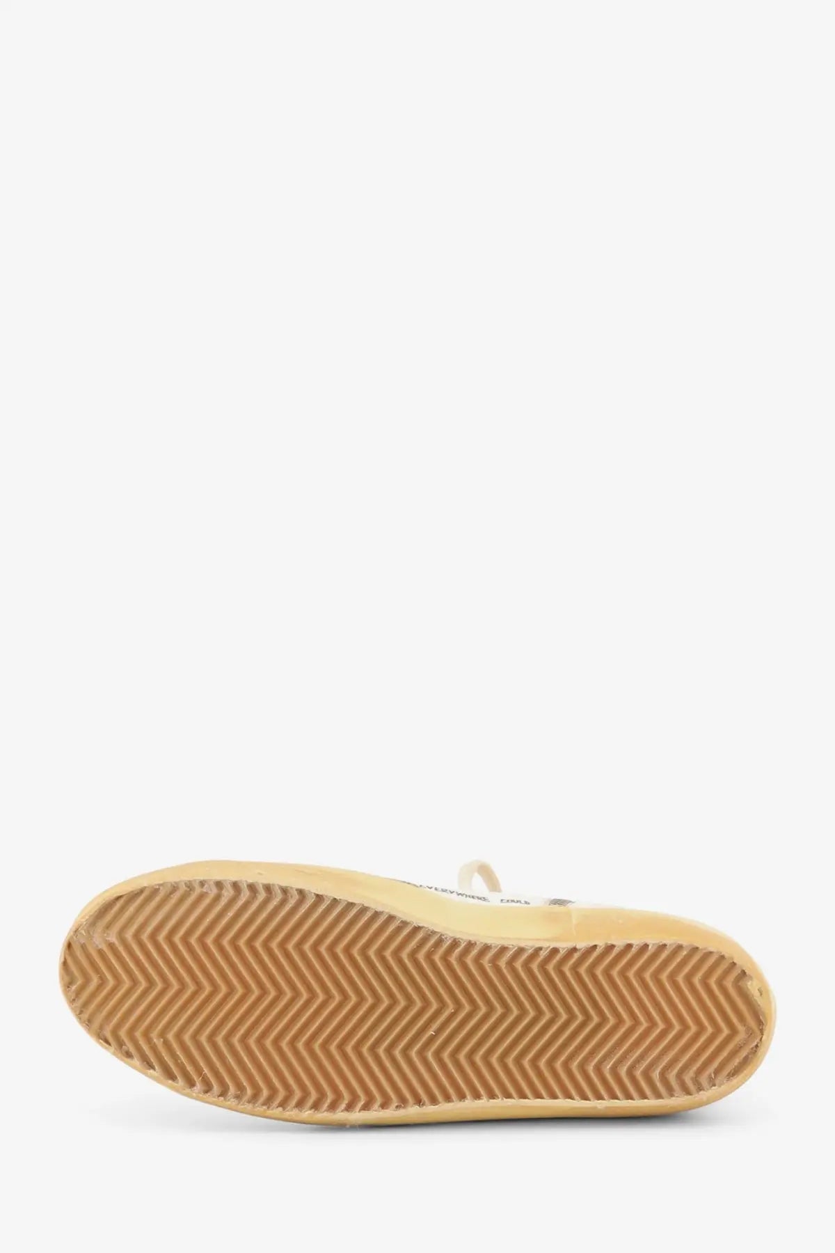 Beige rubber sole with chevron tread pattern on golden goose women’s black leather sneakers back side