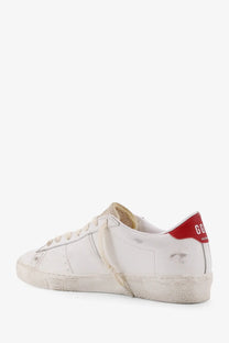 Golden Goose women’s Matchstar leather sneaker in white with distressed texture and red heel tab shown from the back