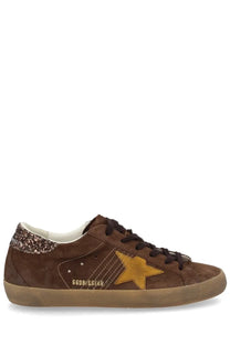 Brown suede golden goose women’s super star low-top sneaker with gold star logo and glittery brown heel tab