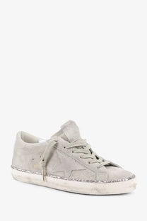 Golden Goose women’s Super Star beige suede sneaker with a glittery silver star and distressed white rubber sole