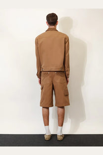 Gucci men’s beige canvas jacket with collar and buttoned cuffs worn over matching cargo shorts