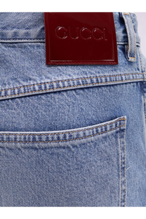 A glossy burgundy leather patch with the embossed gucci logo sewn on the back of light-wash gucci men’s slim fit jeans