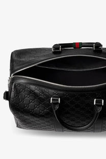 Black Gucci men’s coated canvas GG emblem travel duffel bag with leather, signature interlocking g pattern, and red-green webbing handle