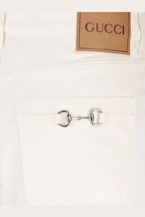 White Gucci men’s denim trousers featuring a silver horsebit closure on the front pocket in white denim material