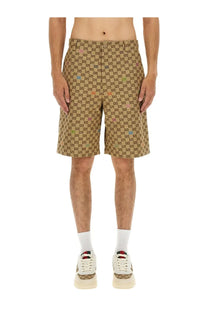 Beige Gucci men’s fabric shorts featuring a repeating GG logo pattern with subtle multicolored accents