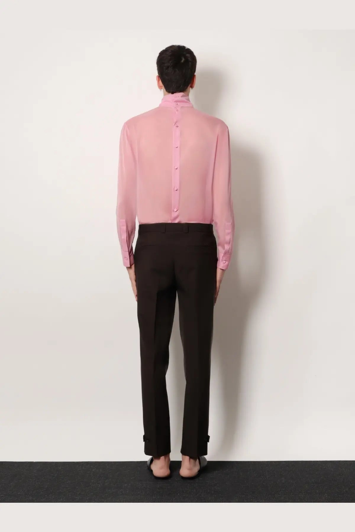 A delicate pink sheer button-up shirt with high collar and long sleeves paired with gucci men’s brown gabardine wool trousers