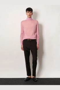 A soft pink long-sleeved turtleneck sweater with smooth knit texture paired with gucci men’s brown gabardine wool trousers