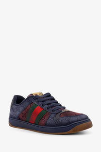 Navy blue gucci men’s gg bicolor fabric sneaker with red green striped panel woven gg supreme fabric upper and tan leather heel tab