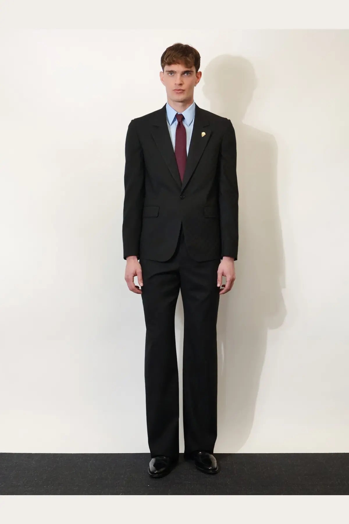 Black tailored suit with single-breasted jacket and trousers worn over gucci men’s gg cotton shirt serenity in light blue