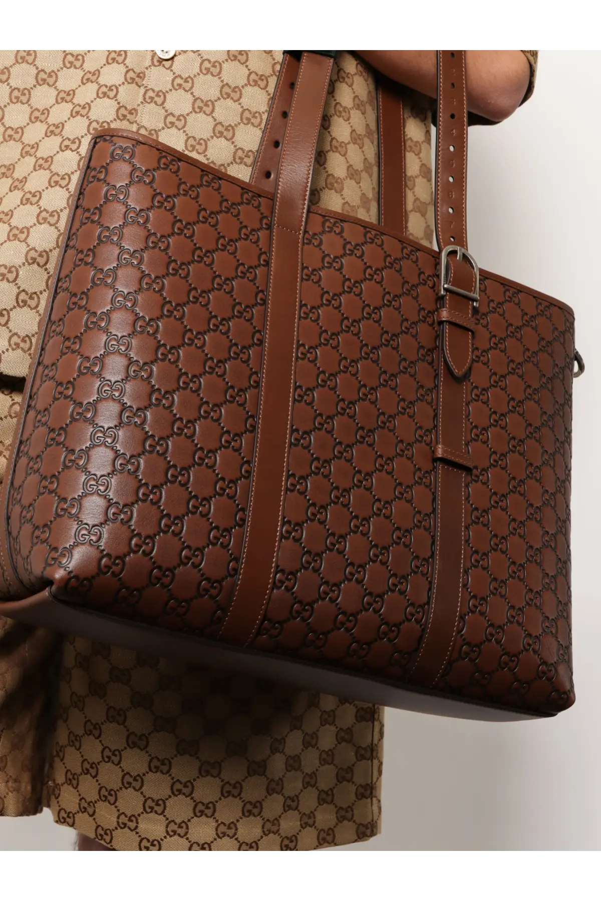 Gucci men’s brown leather tote bag with embossed gg monogram pattern and silver-toned hardware