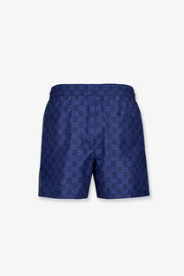 Dark blue gucci men’s nylon swim trunks with repeating interlocking gg logo pattern for swimming and beachwear