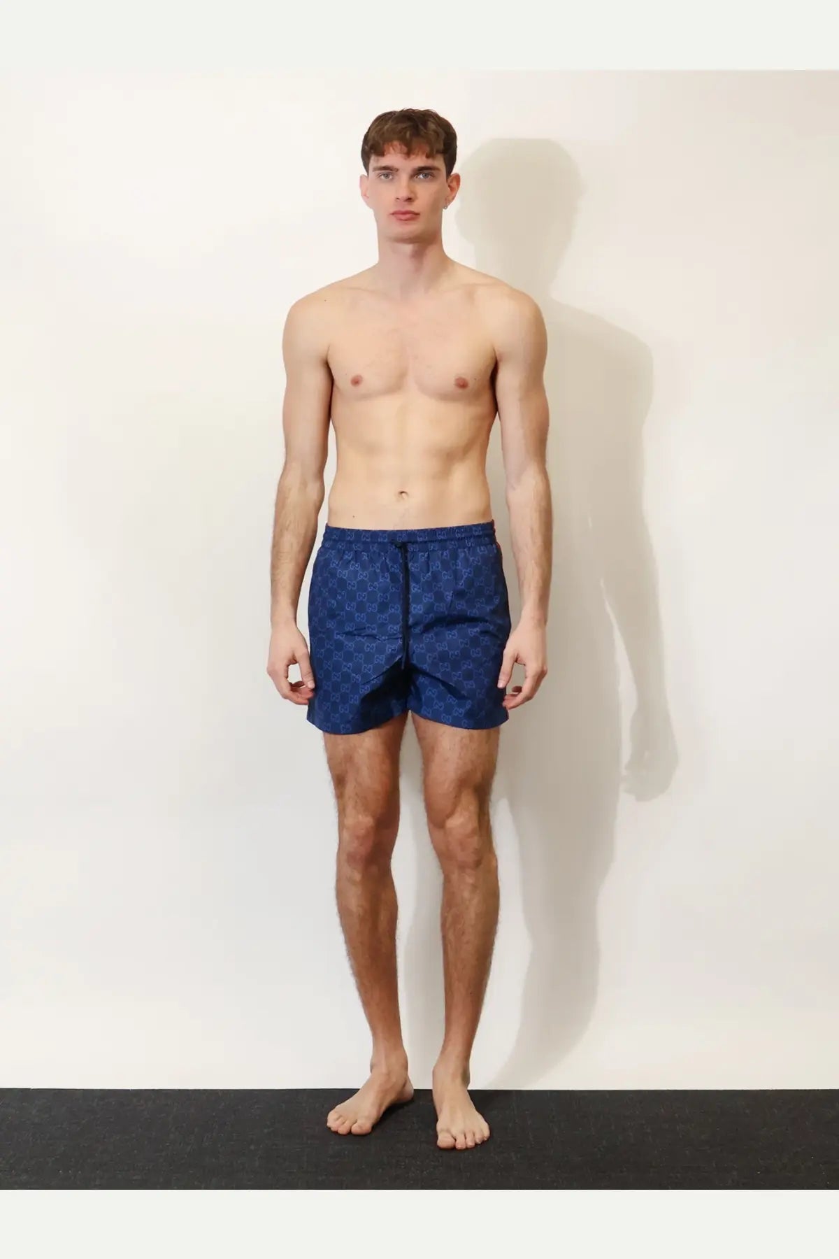 Gucci men’s blue nylon swim trunks with a repeating GG monogram pattern for stylish beachwear