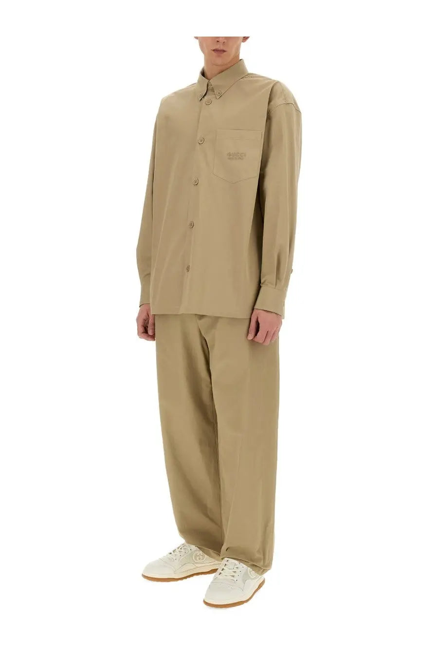 Beige long-sleeved button-up shirt with chest pocket and subtle brand patch paired with gucci men’s brown cotton poplin pants
