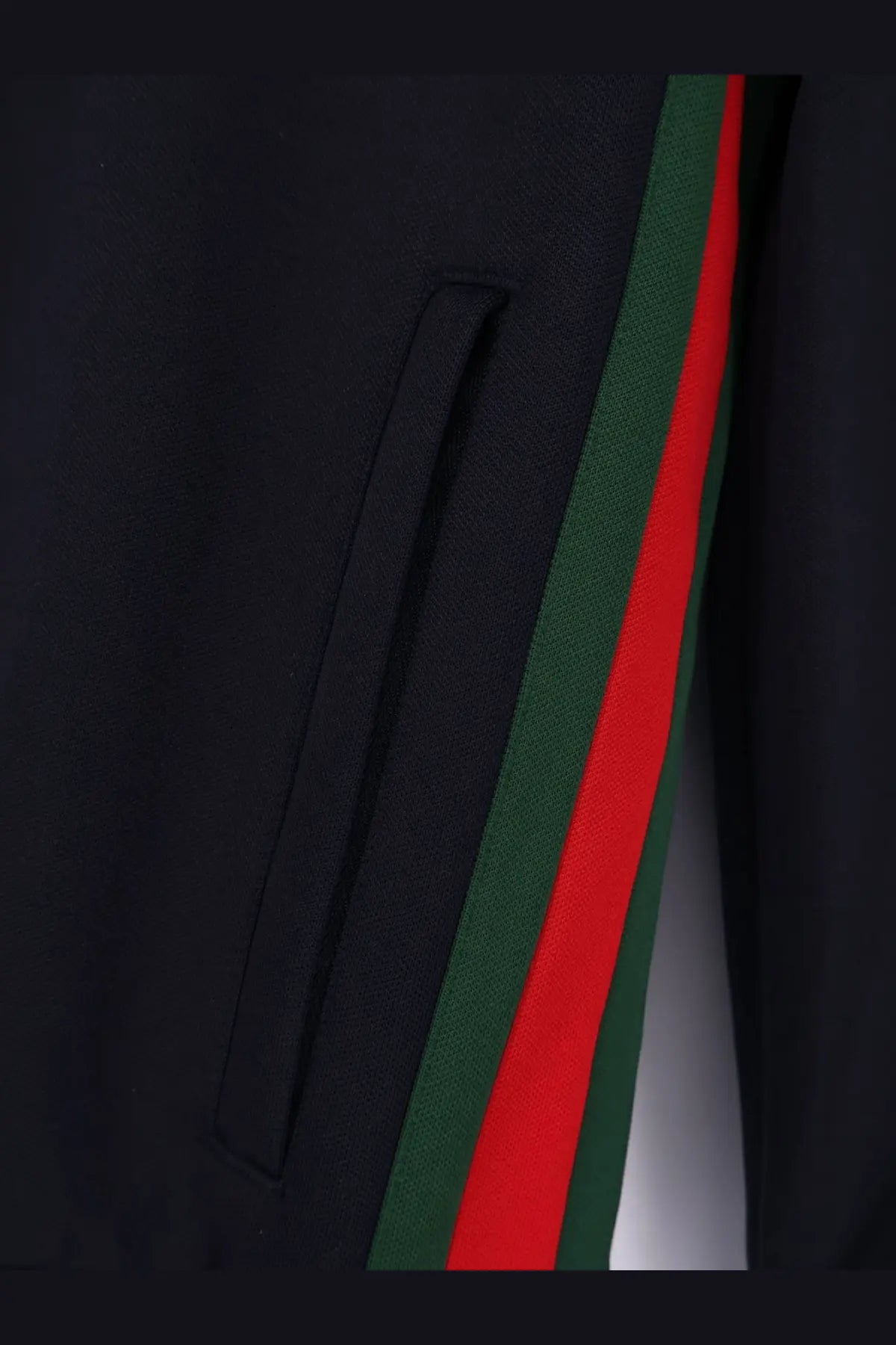 Black Gucci track pants with bold red and green striped side panel paired with Gucci men’s blue jersey sweatshirt