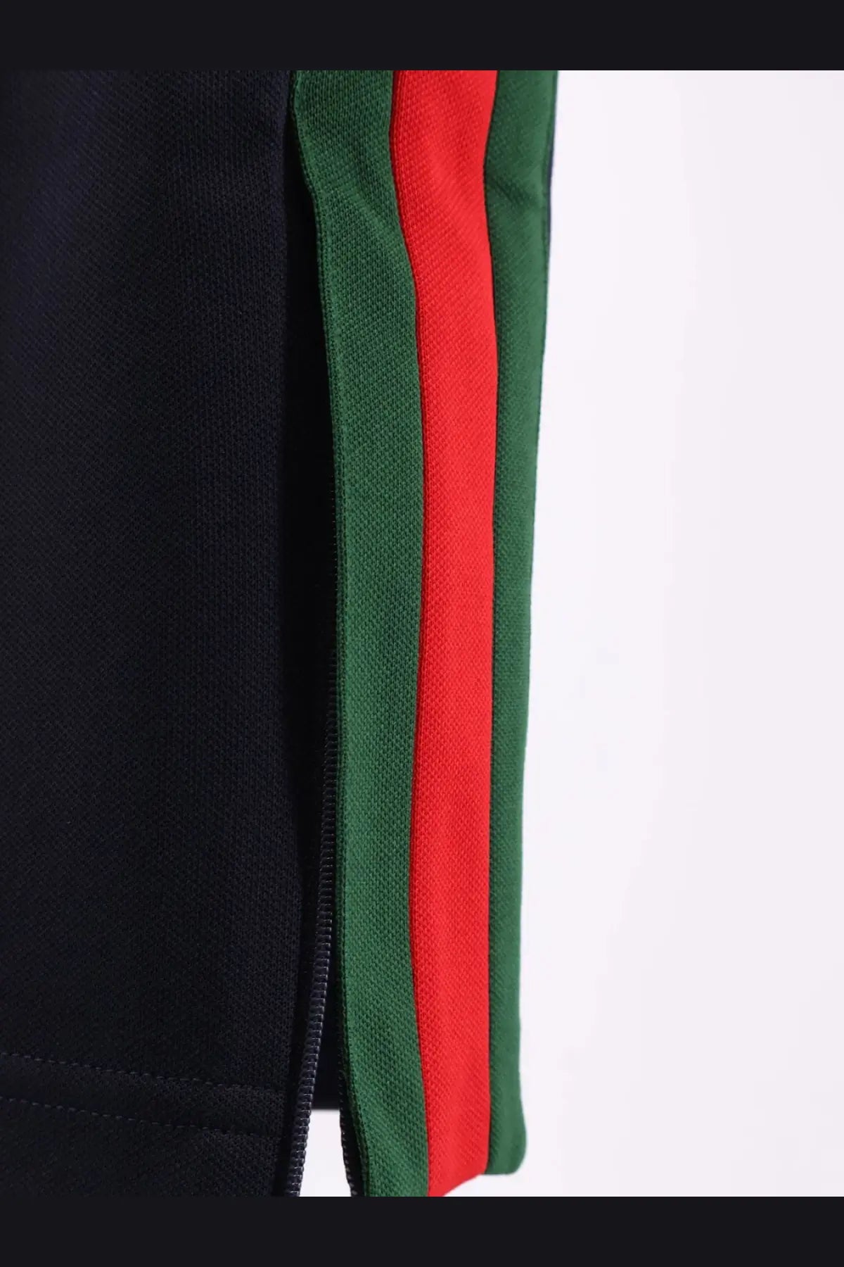 Black Gucci men’s jersey track pants with bold red and green striped side panels in a sporty design