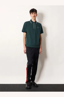 Dark green gucci men’s polo shirt with white trim and embroidered logo paired with blue jersey trousers
