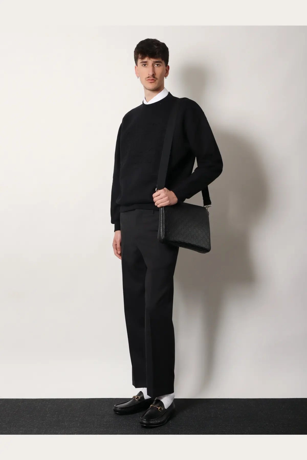Gucci men’s black leather crossbody bag with minimalist design and subtle stitching details