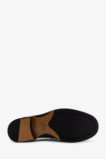 Black Gucci men’s leather loafer sole with tan stitching and embossed brand logo visible on the back side