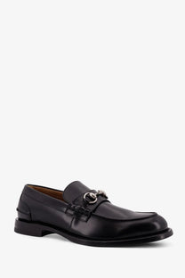 Gucci men’s black leather loafer with silver horsebit buckle showcasing classic luxury design