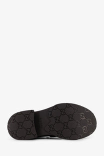 Black gucci men’s leather loafers sole showing iconic interlocking g logo pattern in black rubber material