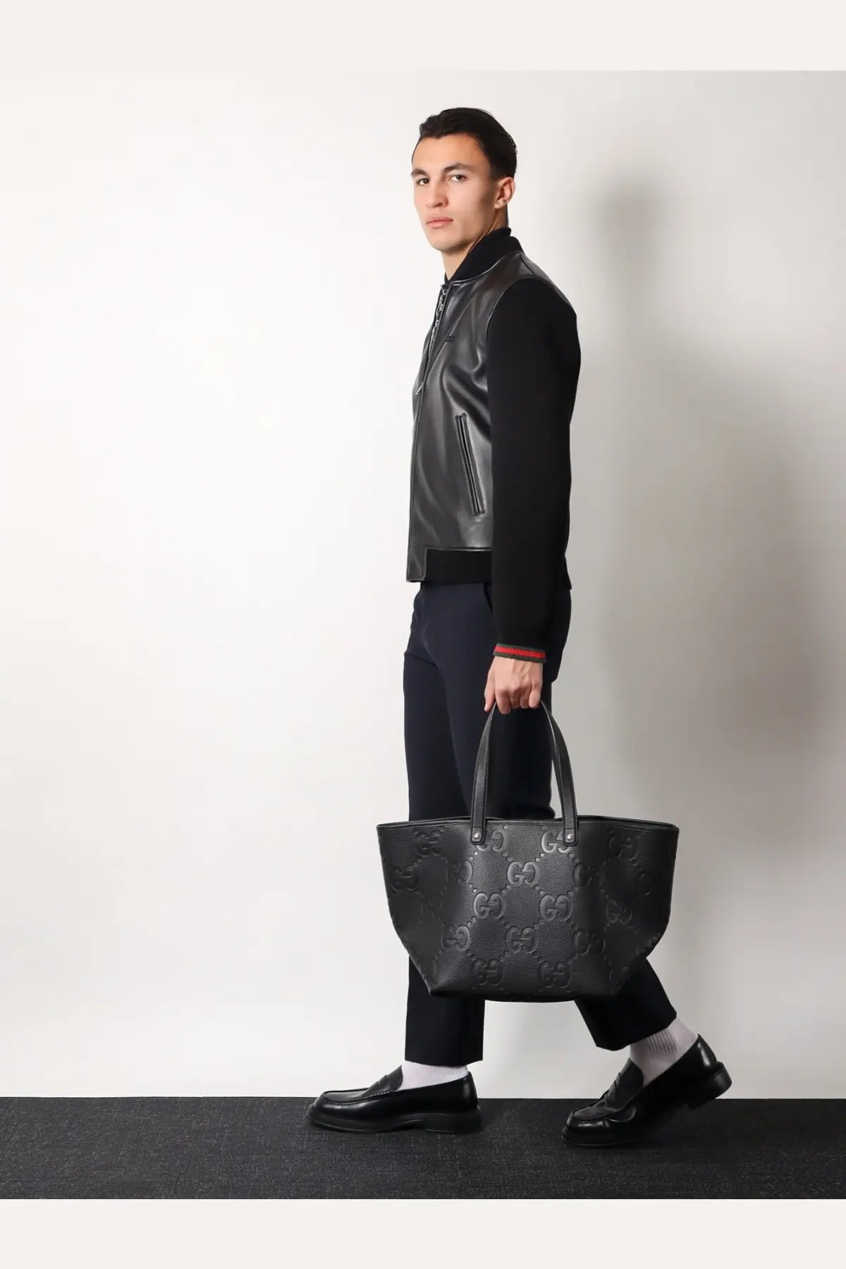 Black gucci gg marmont tote bag with embossed logo pattern complementing gucci men’s leather and wool jacket black