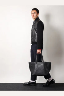Black gucci gg marmont tote bag with embossed logo pattern complementing gucci men’s leather and wool jacket black