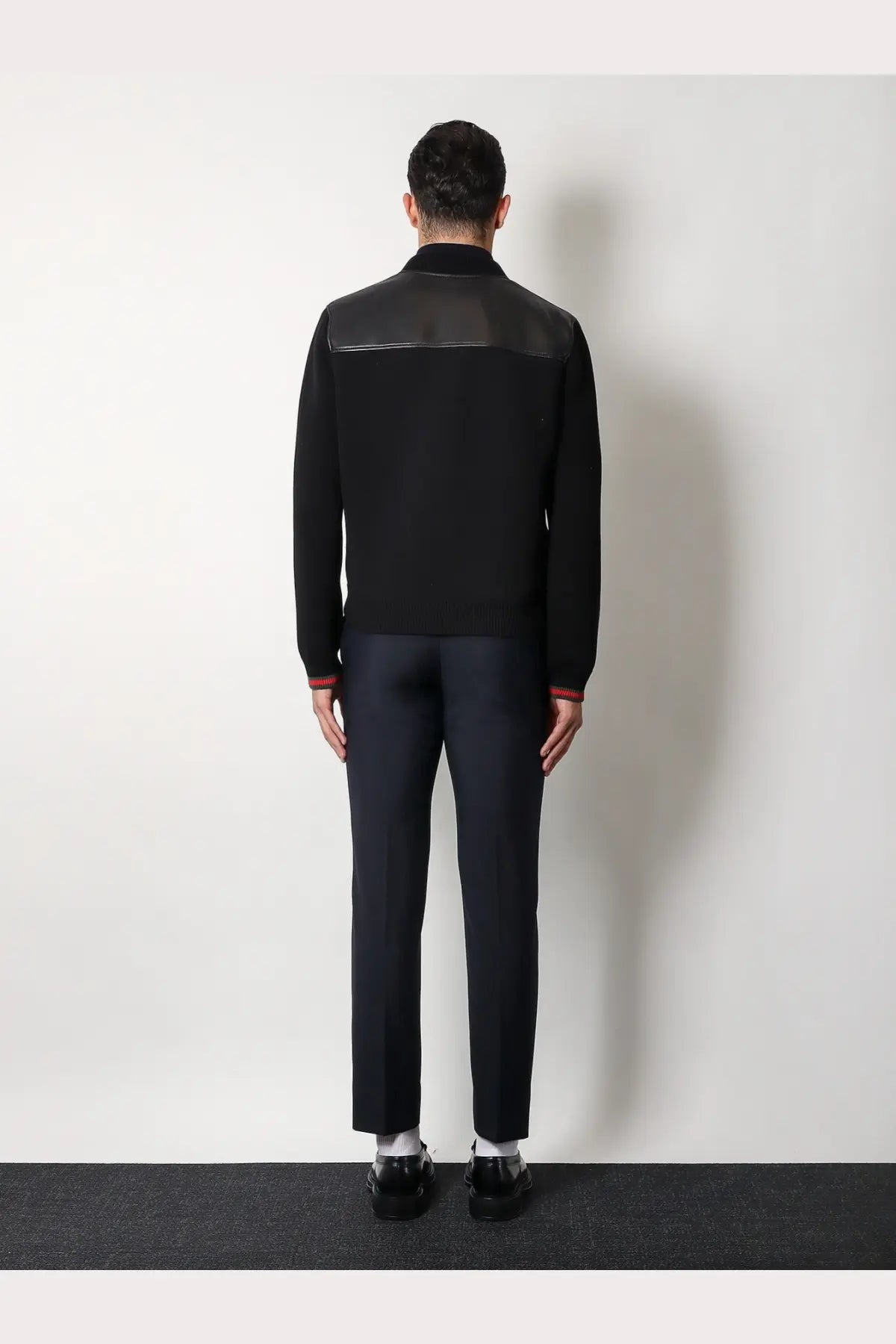 Gucci men’s black knit bomber jacket with contrasting leather shoulder panels and red-trimmed cuffs