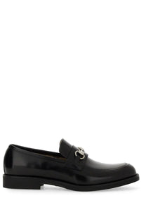 Gucci men’s moccasin black patent leather loafer with silver horsebit buckle visible from the front side
