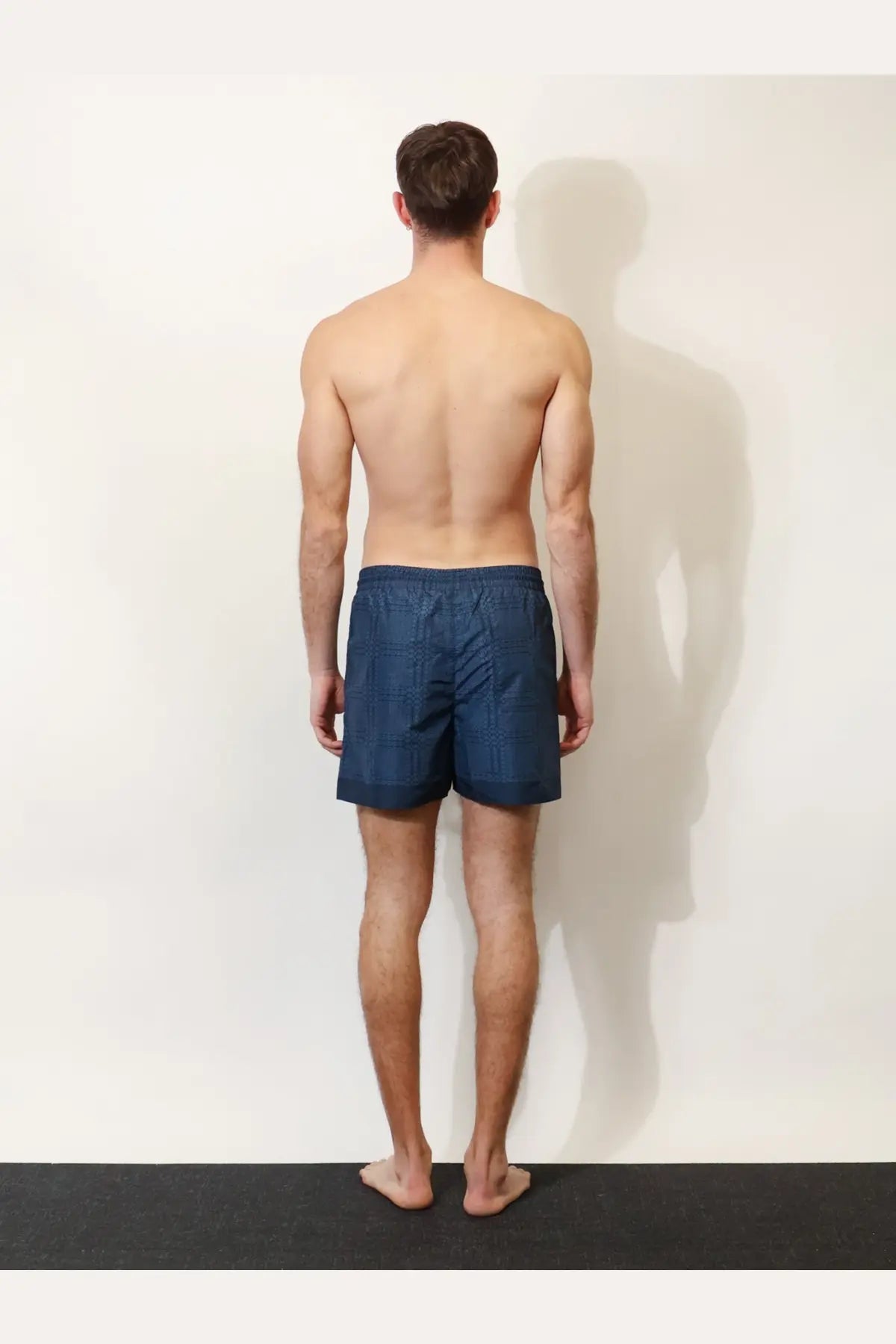 Navy blue Gucci men’s nylon swim trunks with a subtle textured pattern for stylish beachwear