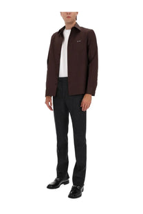 A dark brown gucci jacket with subtle embroidered logo paired with men’s mouliné grey pants