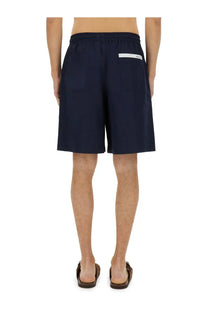 Back view of navy blue cotton gucci men’s poplin shorts with white label on the waistband