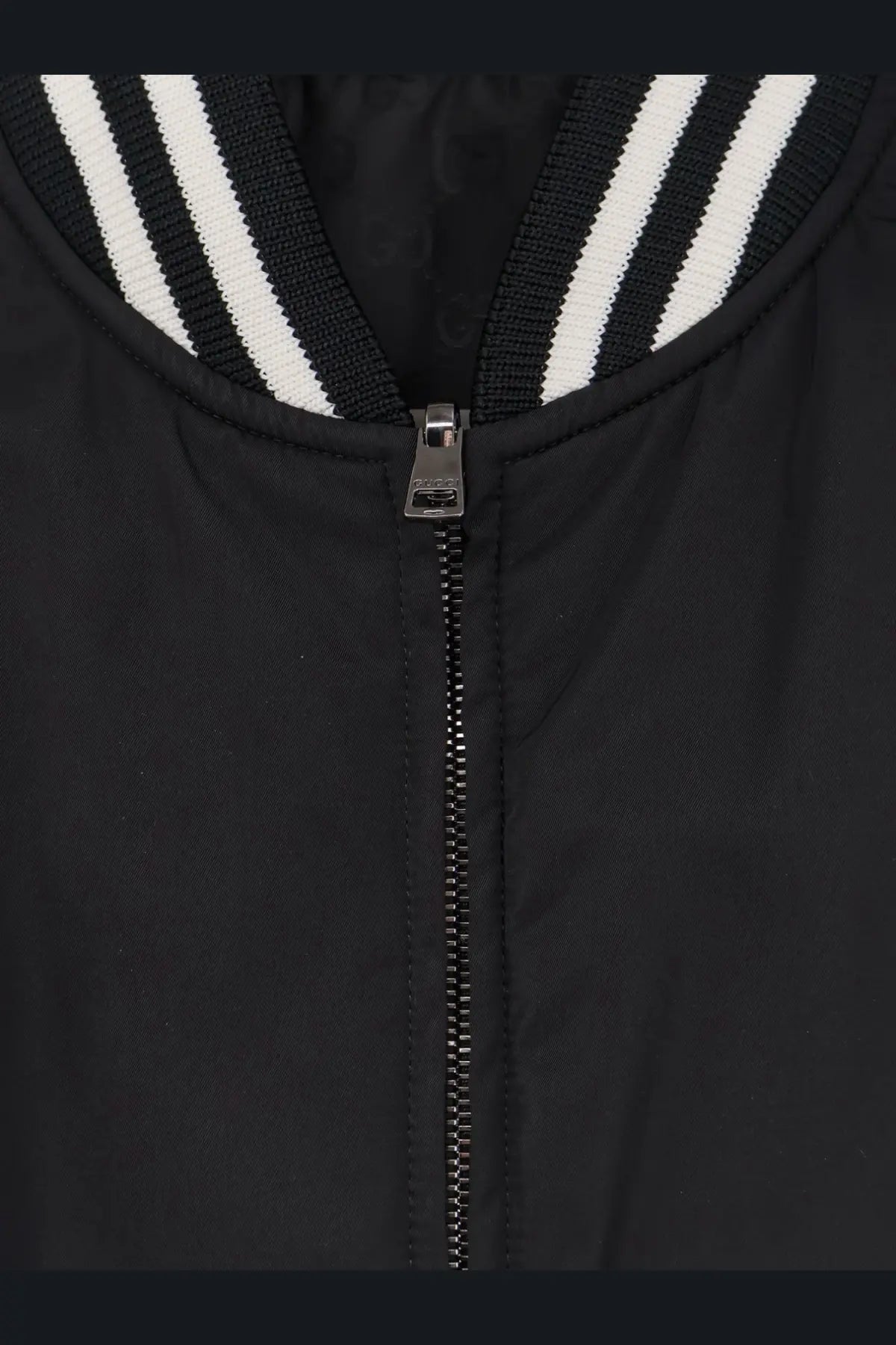 Gucci men’s reversible black bomber jacket with silver zipper and white-striped ribbed collar in nylon material