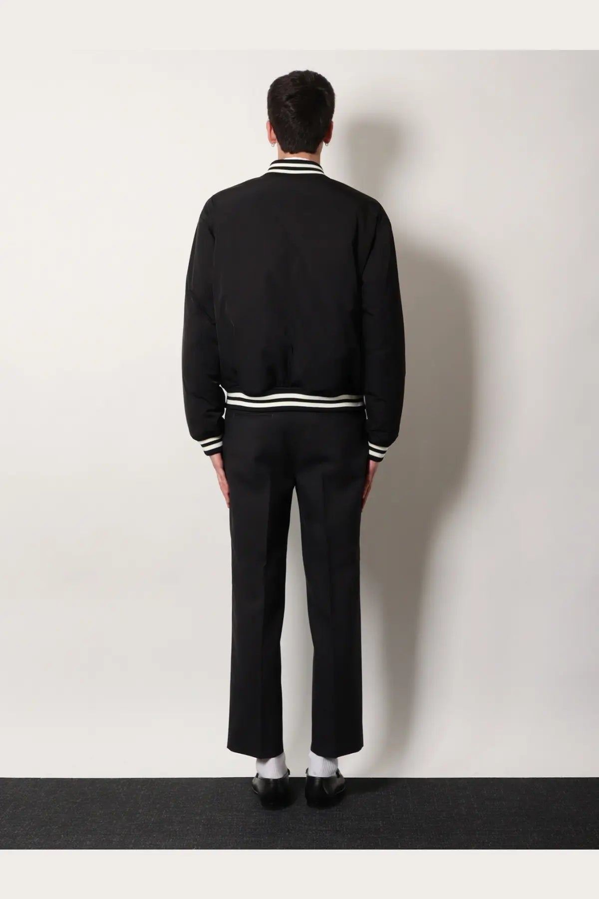 Gucci men’s reversible bomber jacket in black with white striped trim at collar cuffs and waistband