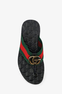 Black Gucci men’s Riviera leather sandals featuring green and red striped strap with gold interlocking GG logo buckle