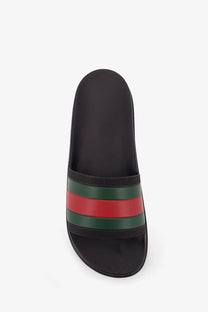 Black gucci men’s rubber slide sandal with signature red and green striped band across the footbed