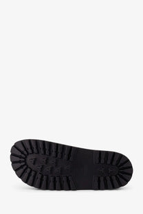 Black rubber sole of gucci men’s rubber slide with deep textured tread and triangular grip markings visible from back side