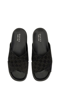 Black Gucci men’s slide sandals with signature GG monogram suede upper and sleek minimalist design multicolor accents